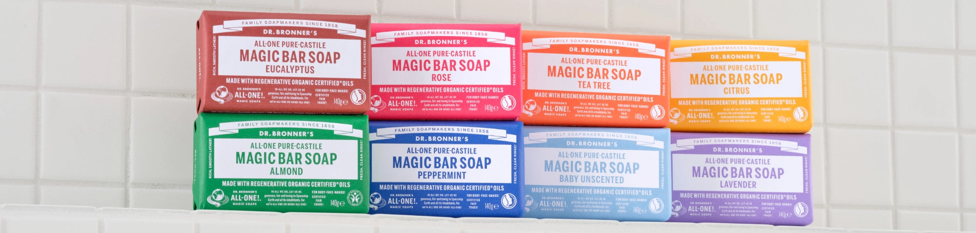 Assorted Dr. Bronner's Magic Bar Soap packages on a tiled wall background