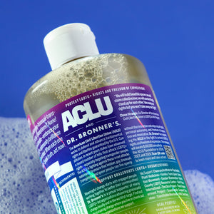 Bottle of Dr. Bronner's Limited-edition Cherry Blossom Pride Soap with rainbow label against a blue background